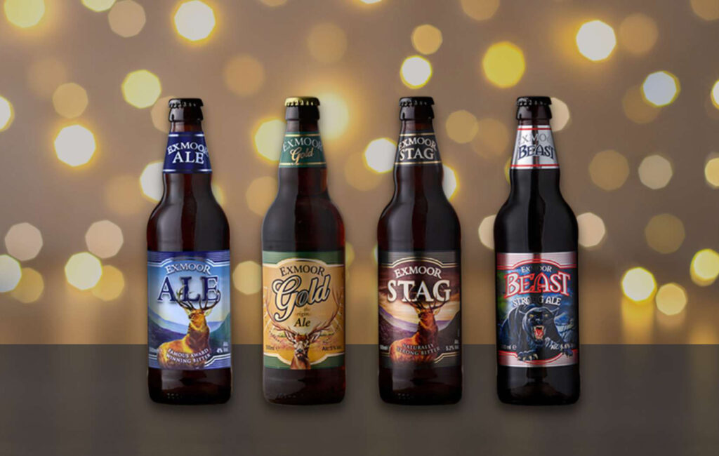 Four bottles of beer, Exmoor Ale, Gold, Stag, and Beast with Christmas lights behind